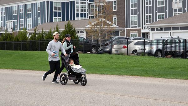 A couple running the race pushing a child in a stroller
